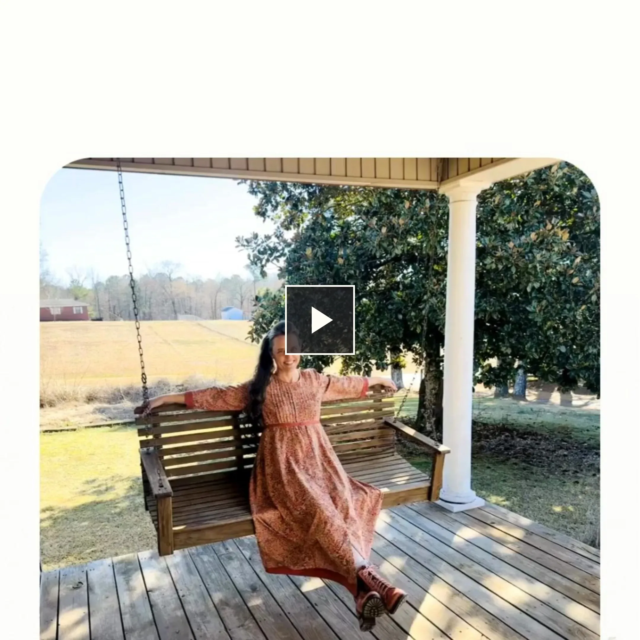 Video ad still — woman in a floral dress on a porch swing